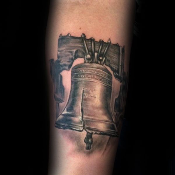 a tattoo on the arm of a man with a large bell in front of him