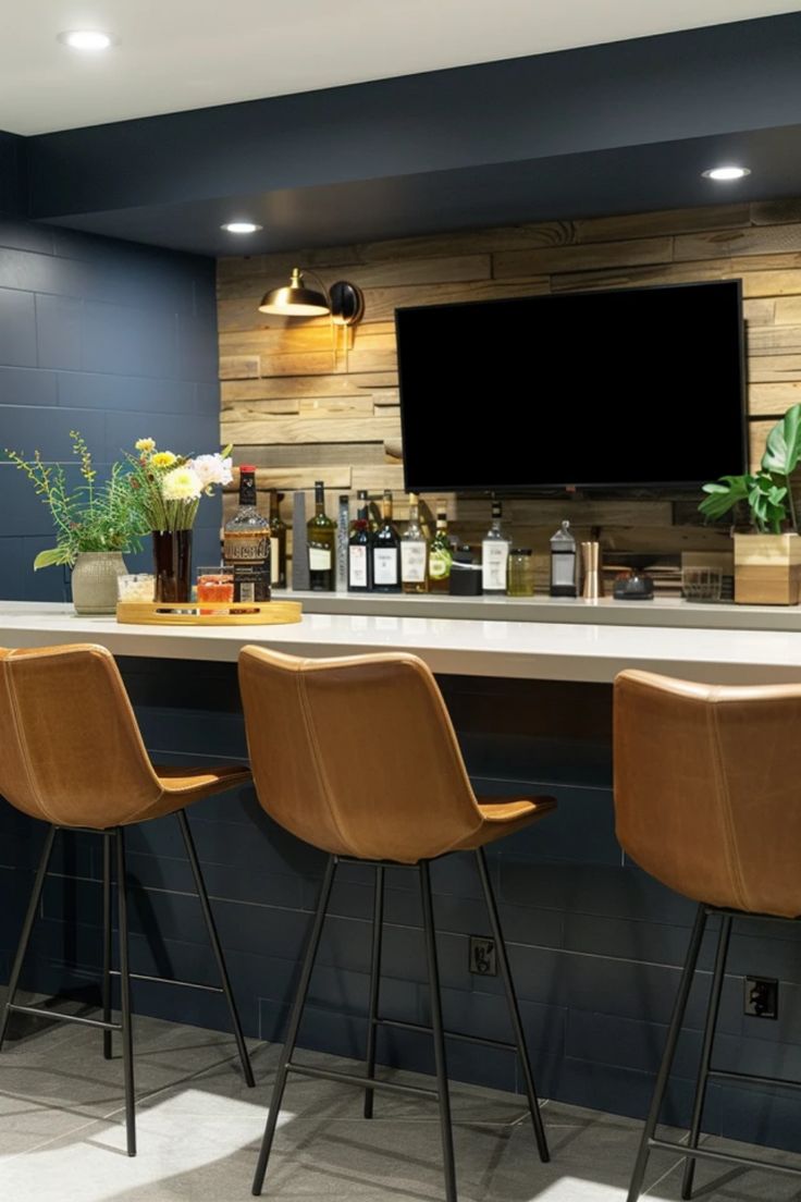 three bar stools sit in front of a television and bottles on the counter top