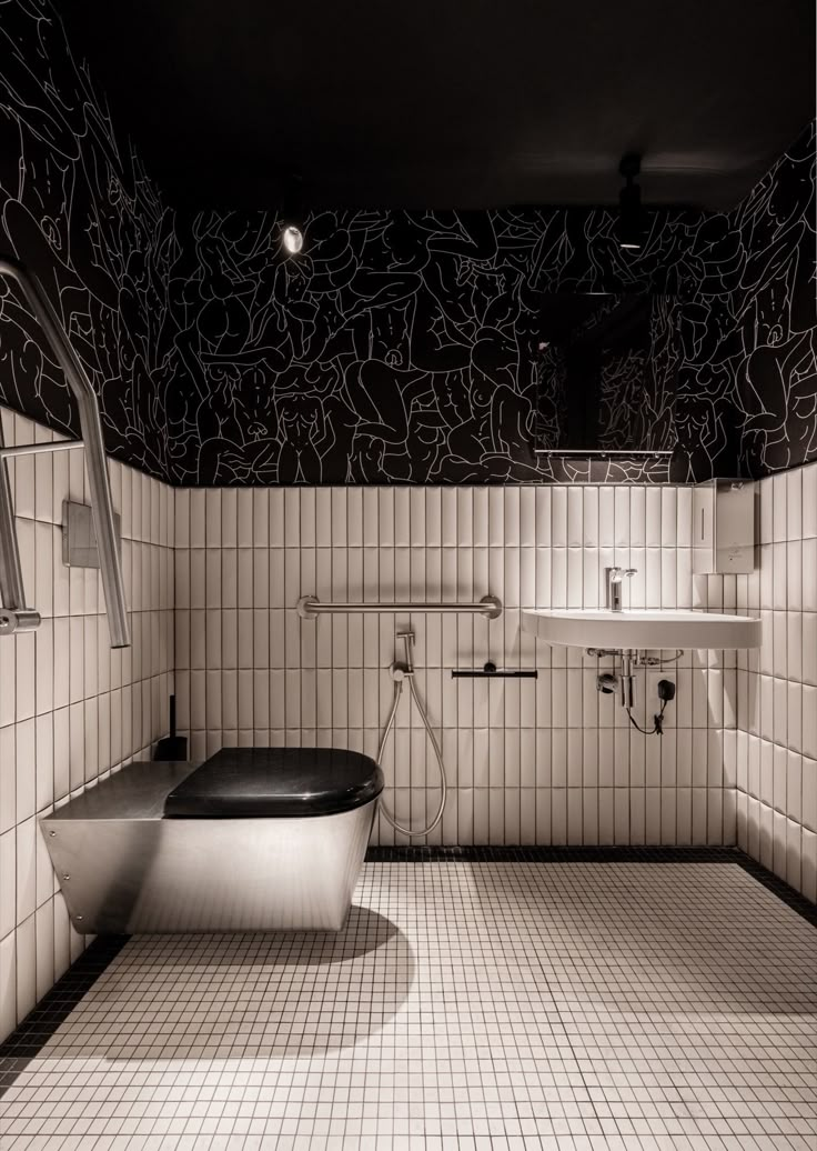 a bathroom with black and white tiles on the walls