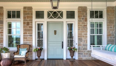 the front porch has two wicker chairs on it