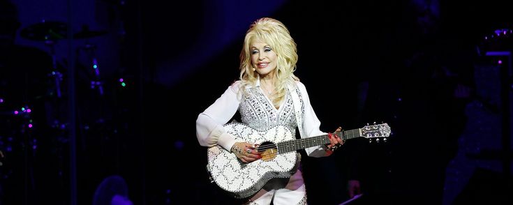 the woman is playing her guitar on stage