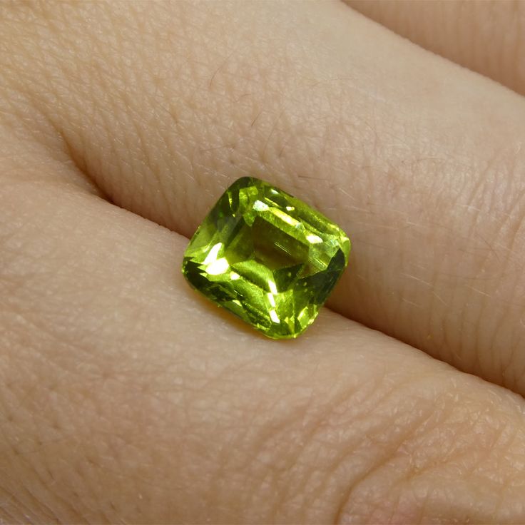 a close up of a person's hand holding a green ring