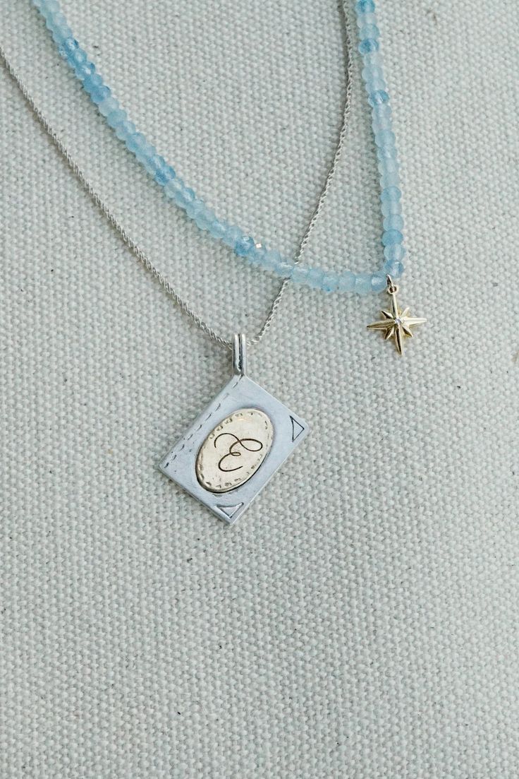 This stunning pendant necklace symbolizes a story unique to the wearer—a story they keep close to their heart. With its intricate details and delicate design, it’s sure to spark up a conversation wherever you go. Enjoy fully personalizable handcrafted engravings on both sides. -hand carved sterling silver book pendant with 14k gold inner plate -personalized letter or number -backside is available for further personalization! Contact us -18" snake chain in sterling silver -pendant dimensions: 3/4 Everyday White Gold Necklace With Charms, Everyday White Gold Necklaces With Charms, Luxury Sterling Silver Pendant Necklace, Everyday White Gold Pendant Charm Necklaces, Heirloom White Gold Locket Necklace, Heirloom White Gold Oval Pendant Necklace, Luxury Sterling Silver Necklace With Oval Pendant, Fine Jewelry Medallion Necklace With Charms, Timeless Pendant Necklace With Charms