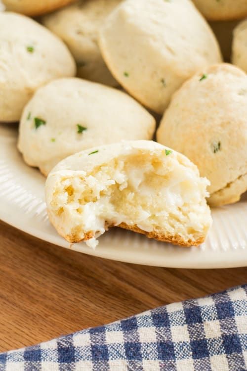 a white plate topped with biscuits next to a blue and white checkered table cloth