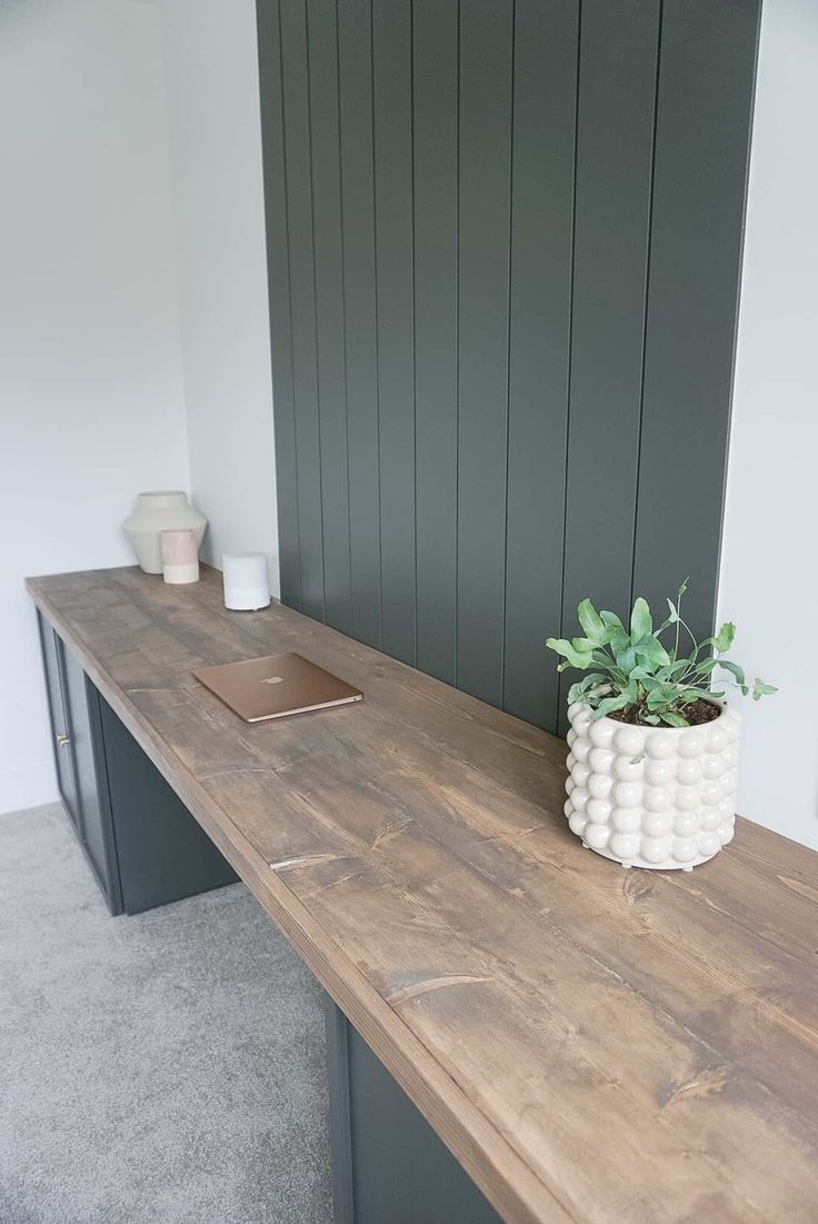 a wooden desk with a potted plant on it