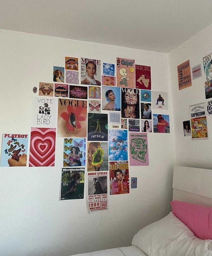 a white bed sitting under a wall covered in pictures and magnets on the wall