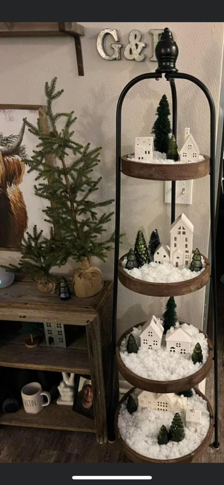 a three tiered display case filled with fake snow and trees on top of it