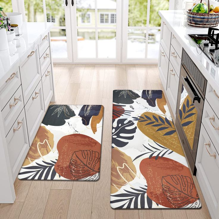 two rugs in the middle of a kitchen with an orange and black floral design