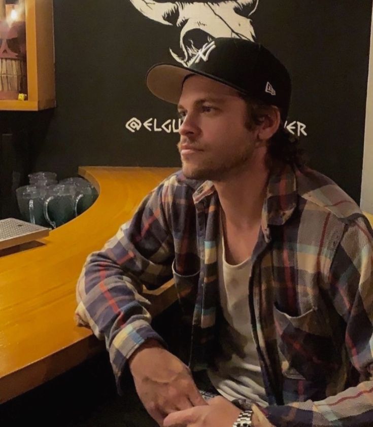 a man sitting in front of a wooden counter