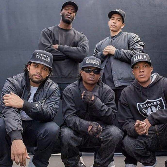 a group of baseball players sitting next to each other in front of a black wall