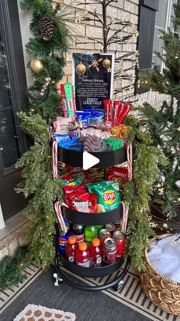 a three tiered christmas tree with candy and cookies on it in front of a house