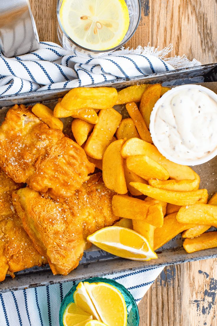 fish and chips with lemon wedges on the side