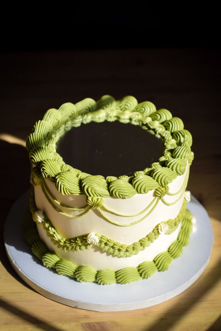 a green and white cake sitting on top of a table