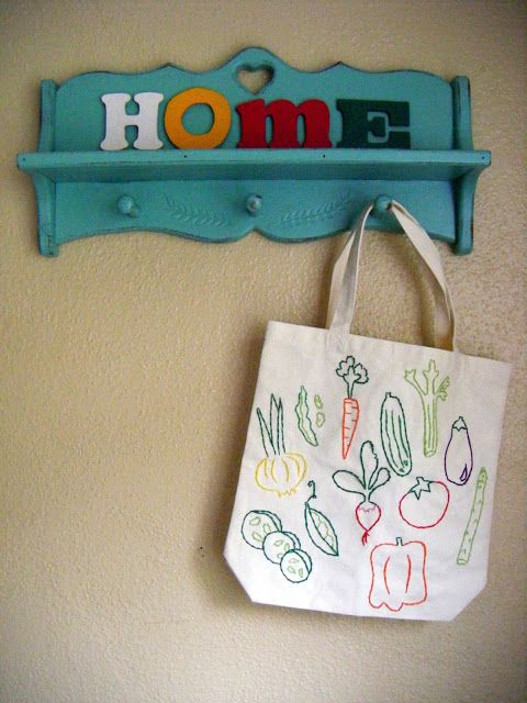 a bag hanging on the wall next to a shelf with a sign that says home