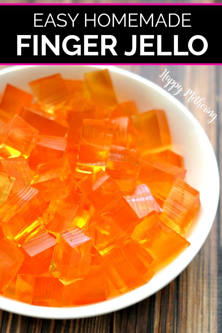 a bowl filled with orange glass cubes on top of a wooden table