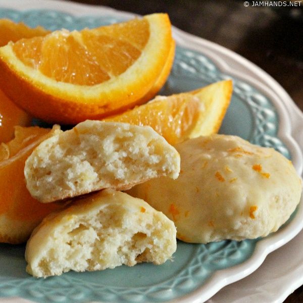 oranges and biscuits on a plate with one cut in half to show the filling