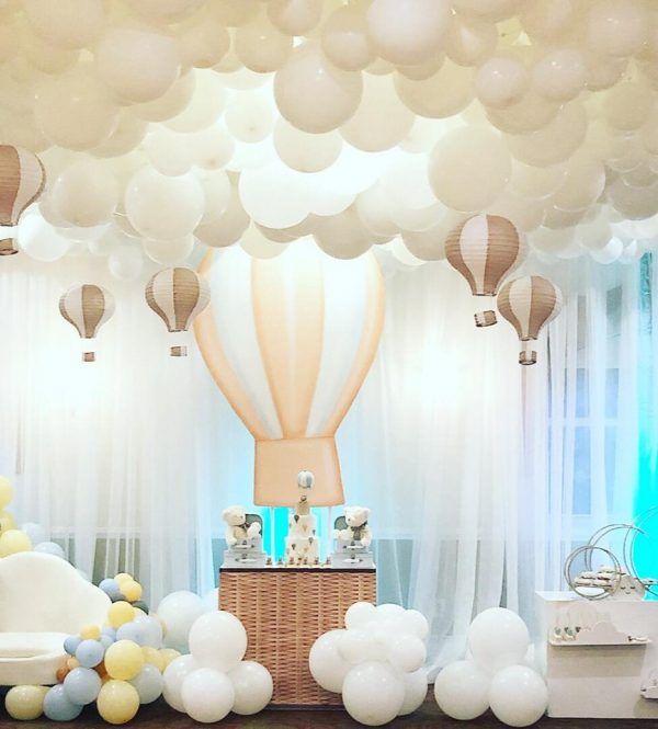 balloons are floating in the air above a baby's crib and other decorations