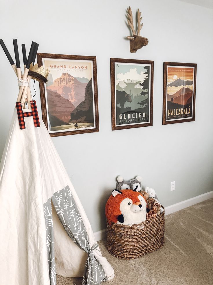 a teepee tent in the corner of a room with pictures on the wall above it