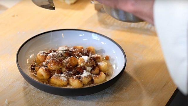 a bowl filled with food sitting on top of a wooden table