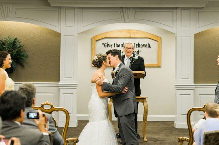 a bride and groom kissing in front of an audience