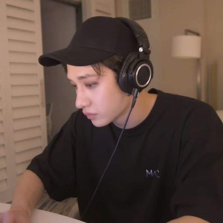 a young man wearing headphones while sitting in front of a laptop computer