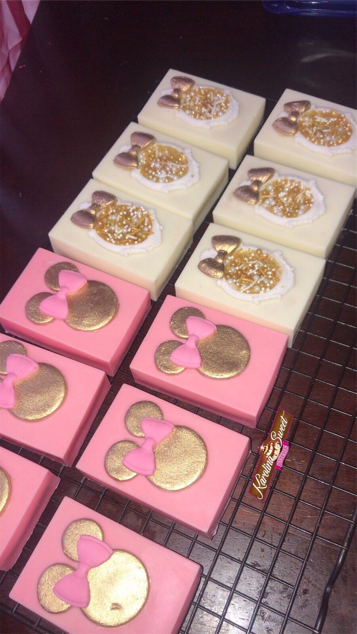 pink and gold mickey mouse cookies on a cooling rack at a birthday party or baby shower