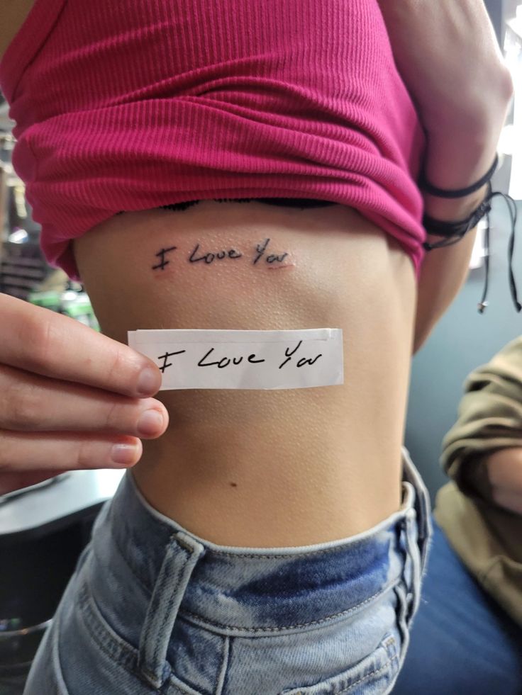 a woman's stomach with a piece of paper taped to it that says i love you