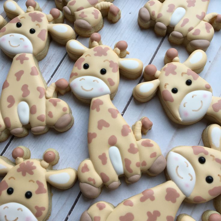 decorated cookies with giraffes and hearts are on a white wooden table top