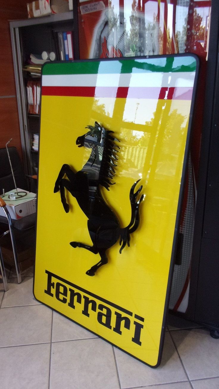 a ferrari sign is shown in front of a bookcase and bookshelf behind it