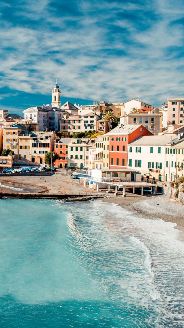 the beach is lined with colorful buildings and blue water