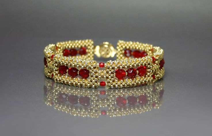 a gold bracelet with red stones on it