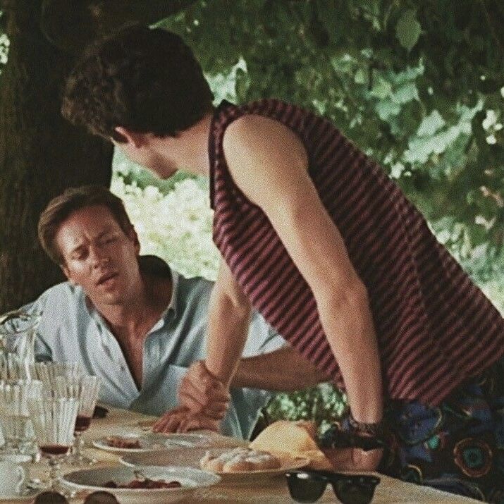 a man and woman sitting at a table with plates of food in front of them