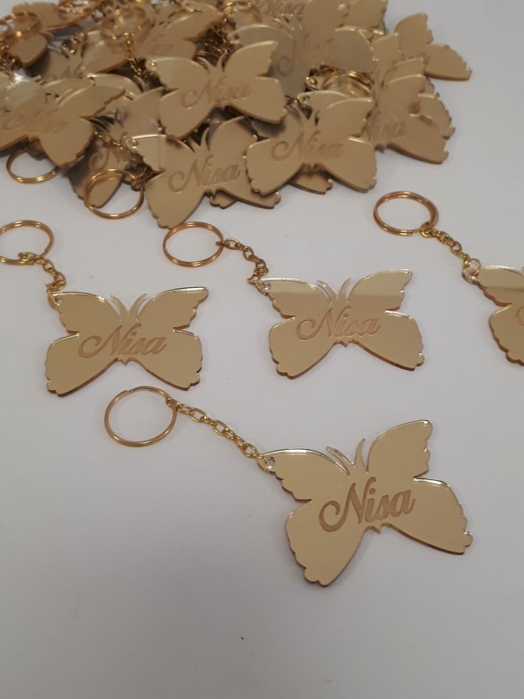 a bunch of gold key chains with butterflies on them