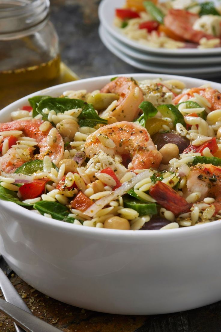 a white bowl filled with pasta salad and shrimp