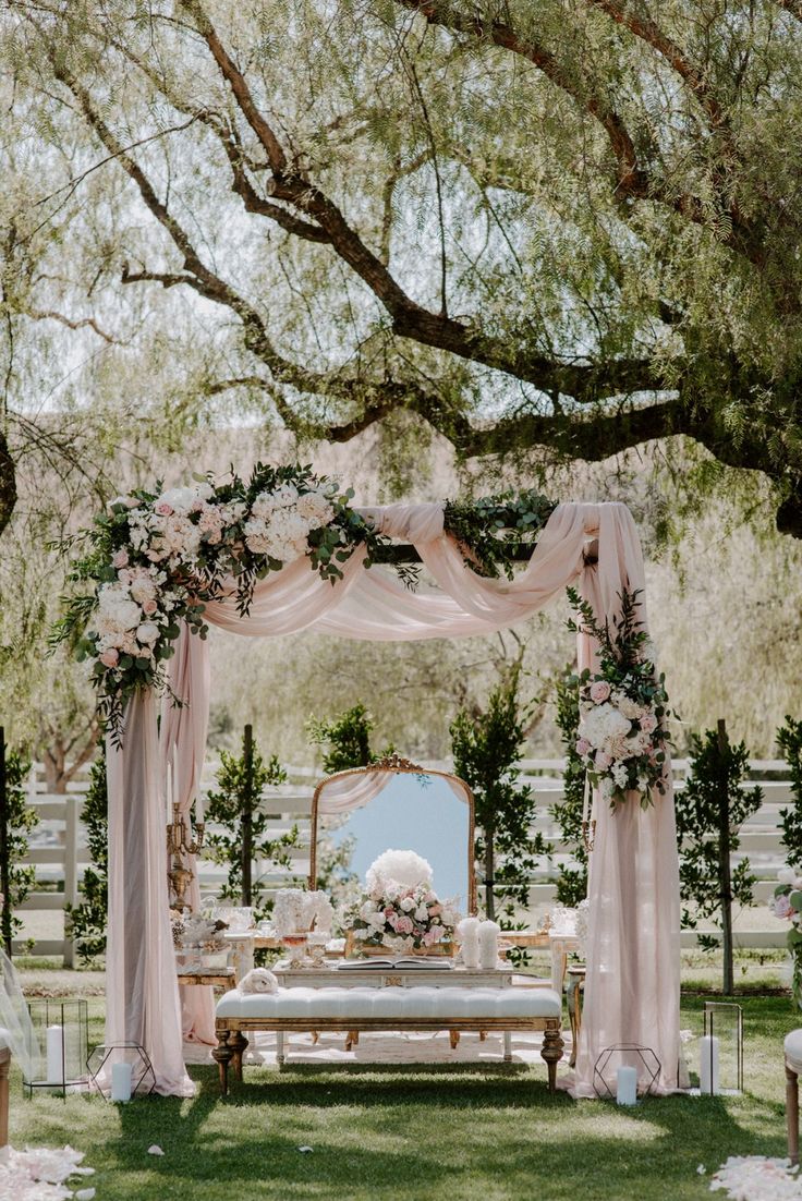 an outdoor wedding setup with flowers and greenery