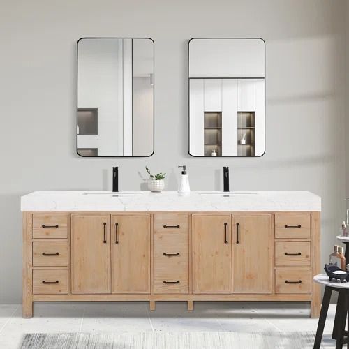 a bathroom with two sinks and mirrors on the wall