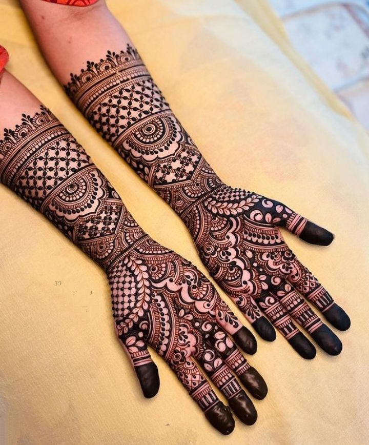 two hands with henna tattoos on them, one is black and the other is red