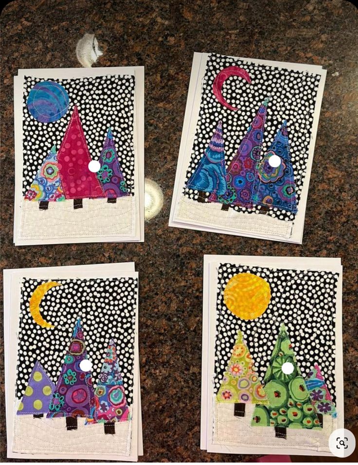 four pictures with different designs on them sitting on a counter top in front of a light switch