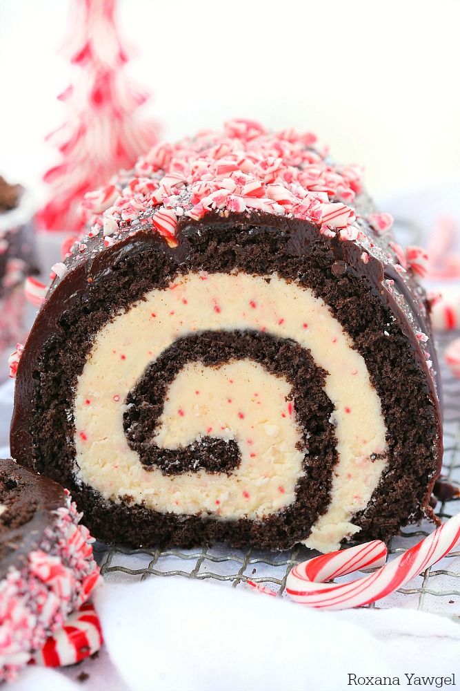 a chocolate cake roll with white frosting and peppermint sprinkles