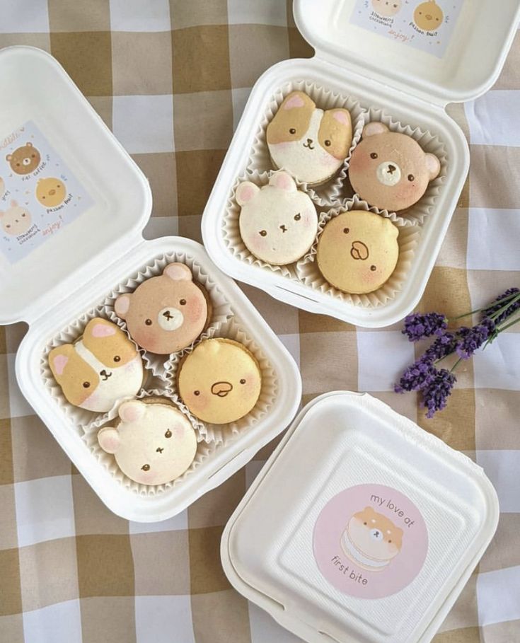 three plastic containers filled with cookies on top of a checkered table cloth