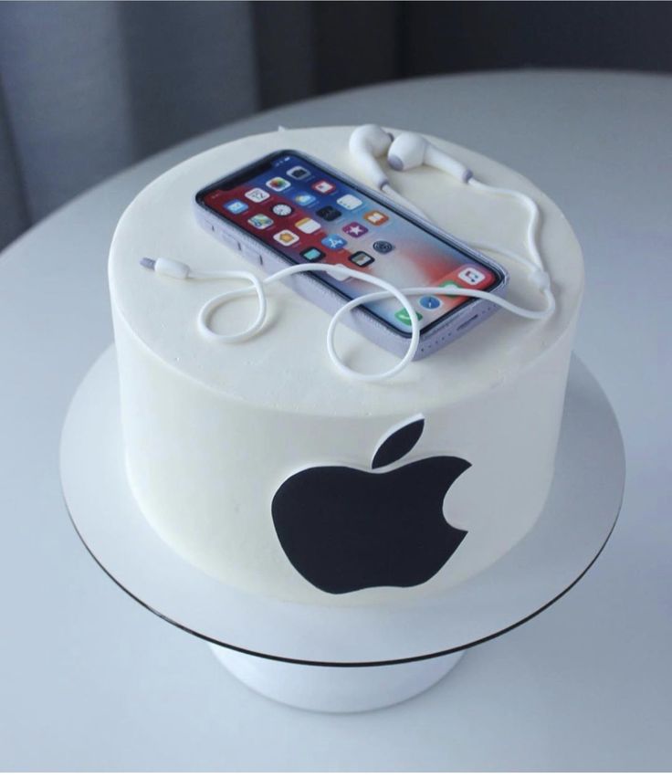 an apple phone is plugged into the charger on top of a white cake