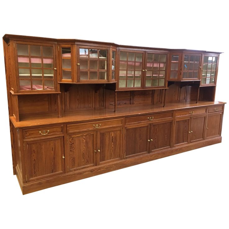 a large wooden cabinet with glass doors and drawers