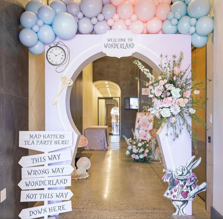 a decorated entrance way with balloons and flowers