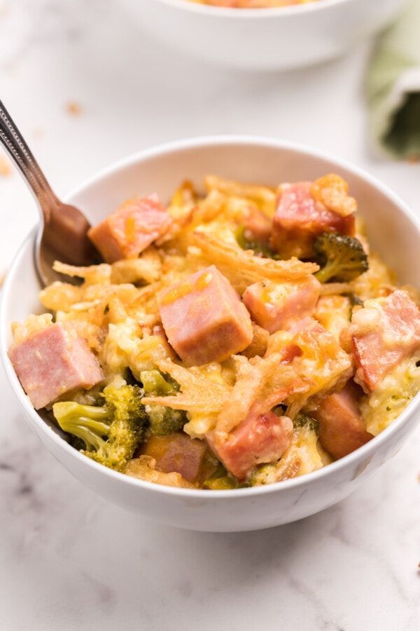 two bowls filled with ham and broccoli casserole