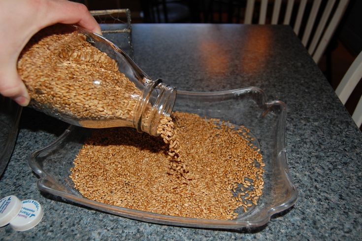 a person pouring grain into a glass bowl