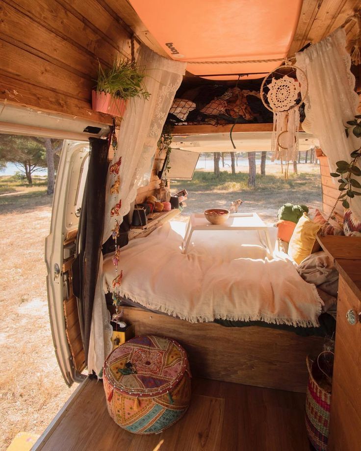 the inside of an rv with a bed in it and lots of decorations hanging from the ceiling