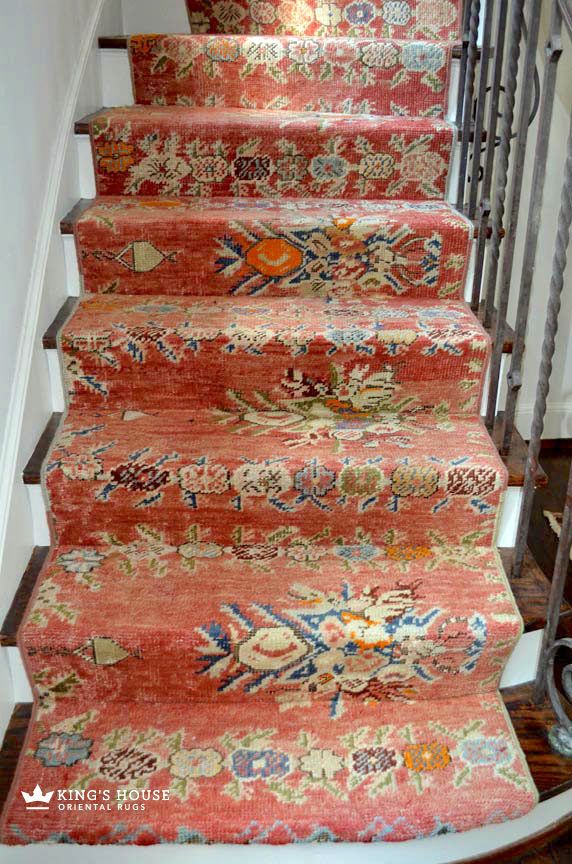 the carpeted stairs are lined with colorful rugs