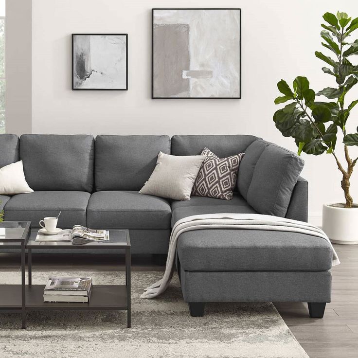 a living room with a gray couch and coffee table in front of a large window