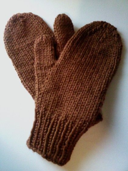 a pair of brown knitted mittens sitting on top of a white countertop