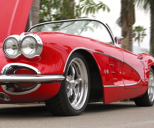 the front end of a red classic car